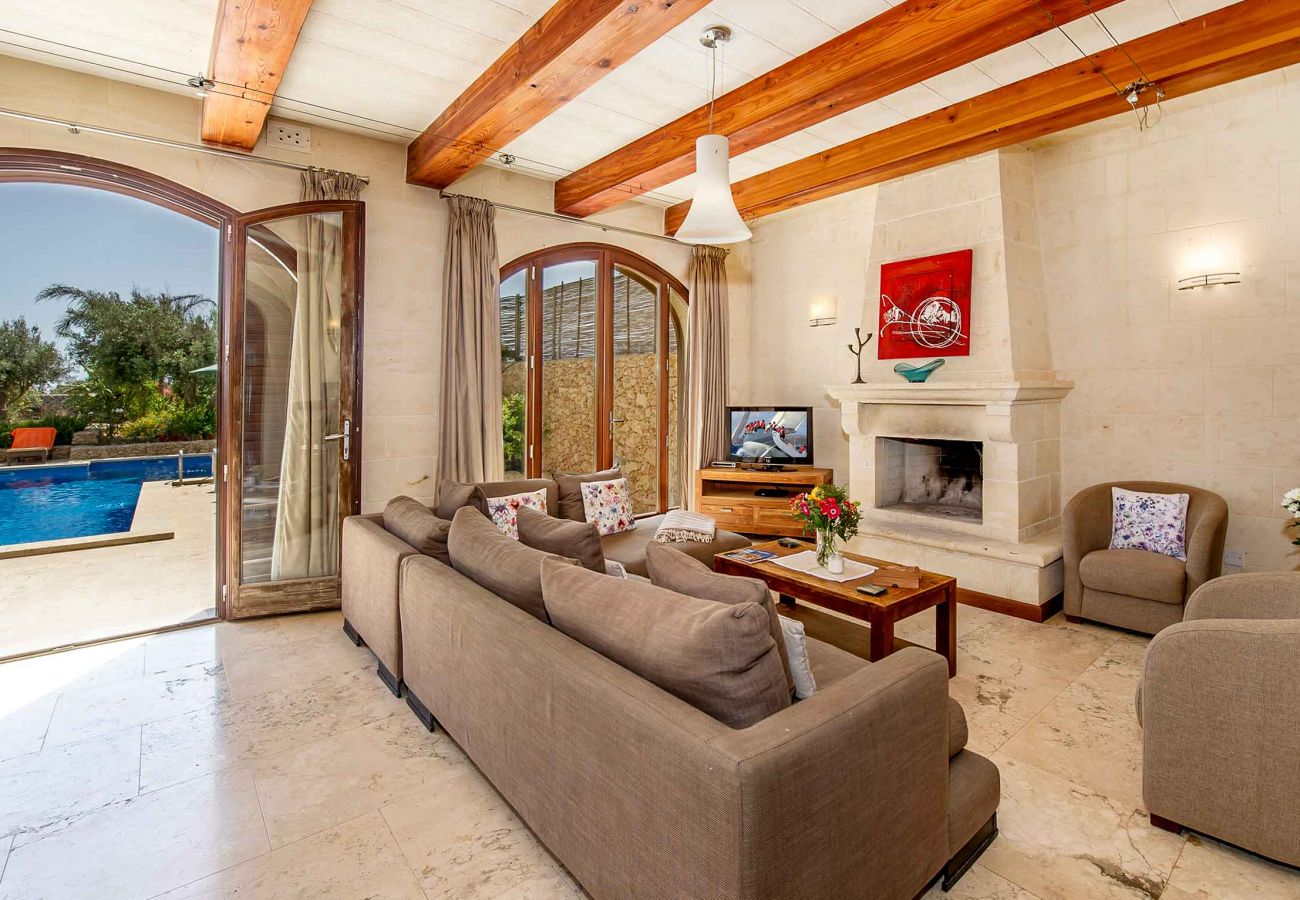 Living room of malta holiday villa with private pool and fireplace